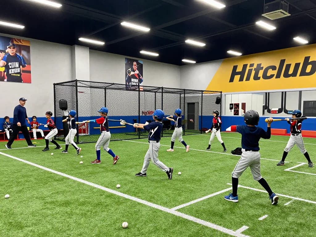 Hitclub baseball players training in vibrant indoor batting cages